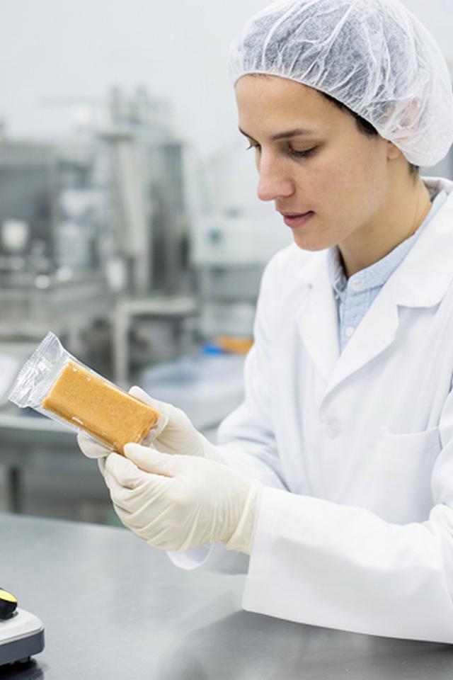 Operatrice in laboratorio controlla una barretta proteica confezionata